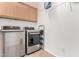 Modern laundry room featuring stainless steel appliances and cabinet storage, adding convenience to chores at 7359 W Kings Ave, Peoria, AZ 85382