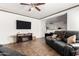 Open-concept living room features tile flooring, ceiling fan, neutral paint, and modern decor at 7359 W Kings Ave, Peoria, AZ 85382