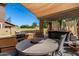 Inviting covered patio featuring a built-in outdoor kitchen, comfortable seating, and relaxing hot tub at 7359 W Kings Ave, Peoria, AZ 85382