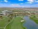 Scenic aerial view of the golf course, a lake, and the community at 77 E Atole Ct, Queen Creek, AZ 85140