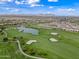 Expansive aerial view showcases the meticulously maintained golf course, a serene lake, and the surrounding community at 77 E Atole Ct, Queen Creek, AZ 85140