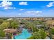 Expansive community pool area with lounge chairs, palm trees, and lush landscaping at 77 E Atole Ct, Queen Creek, AZ 85140