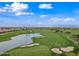 Picturesque aerial view of a lush golf course with a tranquil lake, sand traps, and manicured greens at 77 E Atole Ct, Queen Creek, AZ 85140