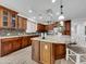 Well-equipped kitchen featuring wooden cabinetry, an island, stainless steel appliances and modern lighting fixtures at 77 E Atole Ct, Queen Creek, AZ 85140
