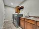 Functional laundry room features a utility sink, wood-look flooring and modern washer and dryer at 77 E Atole Ct, Queen Creek, AZ 85140