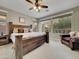 Bright bedroom featuring ceiling fan, and large windows overlooking the landscaped backyard at 77 E Atole Ct, Queen Creek, AZ 85140