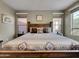 Comfortable main bedroom featuring natural light, ceiling fan and rustic wood furniture at 77 E Atole Ct, Queen Creek, AZ 85140