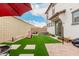 A cozy backyard featuring artificial grass, patio pavers, a grill, and outdoor seating at 8336 E Idaho Ave, Mesa, AZ 85209