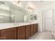 Well-lit bathroom with dual sinks, modern fixtures, and a walk-in shower, offering a clean and functional space at 8336 E Idaho Ave, Mesa, AZ 85209