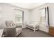 Cozy bedroom with plush carpet, a glider chair, neutral walls, and a white wooden crib at 8336 E Idaho Ave, Mesa, AZ 85209