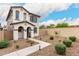 Two-story home featuring a quaint entryway with rock landscaping, modern stucco and stone accents at 8336 E Idaho Ave, Mesa, AZ 85209