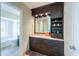A bathroom vanity featuring dark wood cabinets, decorative tile, and a decorative mirror at 8379 E San Salvador Dr, Scottsdale, AZ 85258