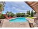 Backyard pool with lounge chairs surrounded by lush greenery and clear blue sky at 8379 E San Salvador Dr, Scottsdale, AZ 85258