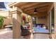 Relaxing covered patio with comfortable seating, fire pit, ceiling fan, and desert landscaping in the yard at 9442 N 106Th Pl, Scottsdale, AZ 85258