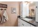 Bathroom features a white vanity cabinet with a marble countertop and decorative wall art at 9442 N 106Th Pl, Scottsdale, AZ 85258