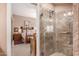 Modern bathroom shower features stone-look tile and a glass door, next to a bedroom at 9442 N 106Th Pl, Scottsdale, AZ 85258
