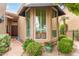 Charming home entrance with bay window and beautifully landscaped front yard with lush plants and desert landscape at 9442 N 106Th Pl, Scottsdale, AZ 85258