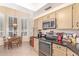 Kitchen with tile flooring and beige cabinetry with stainless steel appliances and breakfast nook at 9442 N 106Th Pl, Scottsdale, AZ 85258