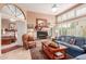 Cozy living room featuring a fireplace, large windows with shutters, and comfortable seating at 9442 N 106Th Pl, Scottsdale, AZ 85258