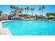 A refreshing view of a large community pool with clear blue water, set against a backdrop of palm trees and a building at 9442 N 106Th Pl, Scottsdale, AZ 85258