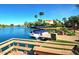 Scenic waterfront view with a boat docked and palm trees swaying in the breeze with a glimpse of a beautiful building at 9442 N 106Th Pl, Scottsdale, AZ 85258