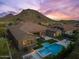 Sprawling home featuring a sparkling pool and outdoor kitchen, against a backdrop of a picturesque mountain at 10778 N 137Th St, Scottsdale, AZ 85259