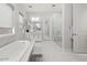 An elegant bathroom featuring marble floors, a soaking tub, a walk-in shower, and dual sinks at 10778 N 137Th St, Scottsdale, AZ 85259