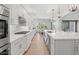 Modern white kitchen with quartz countertops, stainless steel appliances, and barstool seating at 10778 N 137Th St, Scottsdale, AZ 85259