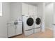 Bright laundry room featuring front-load washer and dryer with storage cabinets and a utility sink at 10778 N 137Th St, Scottsdale, AZ 85259