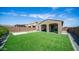 Beautiful backyard features a lush lawn, patio, and sliding glass door to the home's interior at 13511 W Cassia Trl, Peoria, AZ 85383
