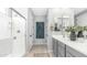 Bright bathroom featuring a glass enclosed shower and gray vanity with a double sink at 13511 W Cassia Trl, Peoria, AZ 85383