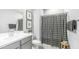 Modern bathroom with gray vanity, patterned shower curtain and framed pictures at 13511 W Cassia Trl, Peoria, AZ 85383