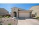 Charming single-story home featuring a neutral color palette, desert landscaping, and a welcoming arched entryway at 13511 W Cassia Trl, Peoria, AZ 85383
