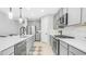 Well-lit kitchen featuring stainless steel appliances, gray cabinetry, a white backsplash, and a stylish black faucet at 13511 W Cassia Trl, Peoria, AZ 85383
