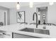 Close-up of a kitchen island featuring a stainless steel sink, elegant faucet, and pendant lighting at 13511 W Cassia Trl, Peoria, AZ 85383