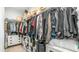 Spacious walk-in closet with ample storage shelves, hanging racks and a suitcase at 13511 W Cassia Trl, Peoria, AZ 85383