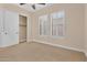 A bright bedroom featuring a ceiling fan, large windows, and closet at 1608 W Calle De Pompas --, Phoenix, AZ 85085
