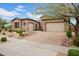 Elegant home with a paver driveway leading to a two-car garage and a well-manicured desert landscape at 1608 W Calle De Pompas --, Phoenix, AZ 85085