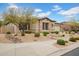 Charming home featuring a stone facade, desert landscaping, and mature trees in a well-maintained front yard at 1608 W Calle De Pompas --, Phoenix, AZ 85085