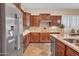 Traditional-style kitchen featuring granite counters, dark cabinets, and stainless steel appliances at 1608 W Calle De Pompas --, Phoenix, AZ 85085