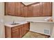 Functional laundry room with sink, counter space, storage cabinets, and tile flooring at 1608 W Calle De Pompas --, Phoenix, AZ 85085