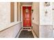 Charming front porch featuring a red door with wreath, decorative signs, and ambient lighting at 17704 W Tasha Dr, Surprise, AZ 85388