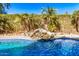 Private backyard pool with a tranquil waterfall and lush, mature landscaping at 17704 W Tasha Dr, Surprise, AZ 85388