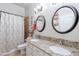 Bathroom with dual sinks, granite counters, and a shower featuring decorative tile at 1919 S Granite St, Gilbert, AZ 85295