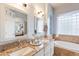 Well-lit bathroom with double sinks, a soaking tub, and tasteful decor, a perfect blend of style and relaxation at 1919 S Granite St, Gilbert, AZ 85295