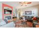 Spacious living room with a cozy fireplace, a ceiling fan, and tile flooring throughout at 1919 S Granite St, Gilbert, AZ 85295