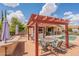 A poolside patio with a pergola, dining table, and built-in outdoor kitchen provides a relaxing outdoor space at 1919 S Granite St, Gilbert, AZ 85295