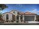 Charming single-Gathering home featuring stucco siding, a tile roof, arched windows and a two-car garage at 20723 W San Miguel Ave, Buckeye, AZ 85396