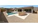 Stunning backyard with a pool, spa, outdoor fireplace, built-in BBQ, and low-maintenance desert landscaping at 20775 W Rattler Rd, Buckeye, AZ 85396