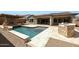 Resort-style backyard showcasing a pool, spa, covered patio, outdoor fireplace, and built-in BBQ at 20775 W Rattler Rd, Buckeye, AZ 85396